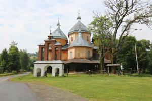 a large building with turrets on top of a grass field at Astroturystyka BYSTRE 2 in Bystre