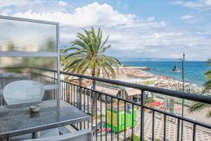 balcón con mesa y vistas a la playa en Albium - Hotel Sul Mare, en Albenga