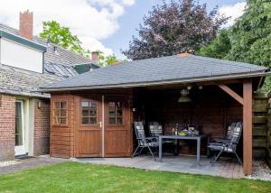 a pavilion with a table and chairs in a backyard at Gastenverblijf Volkel in Volkel