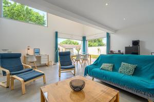 een woonkamer met een blauwe bank en stoelen bij RETOUR DE PLAGE - Maison familiale à 400 m de la plage! in Arradon