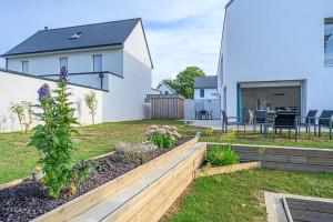 um quintal com uma casa e um jardim em RETOUR DE PLAGE - Maison familiale à 400 m de la plage! em Arradon