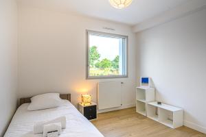 um quarto branco com uma cama e uma janela em RETOUR DE PLAGE - Maison familiale à 400 m de la plage! em Arradon