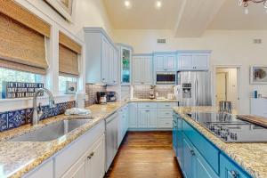 a kitchen with blue cabinets and white appliances at Sunsets At Joe's in St. George Island