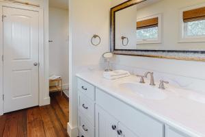 a white bathroom with a sink and a mirror at Sunsets At Joe's in St. George Island +32 photos