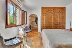 een slaapkamer met een bed, een tafel en een deur bij Casa Llibertat boutique stay with spa in Lliber