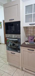 uma cozinha com um fogão e um micro-ondas em Casa vacanze Ķ-HOME em Salerno