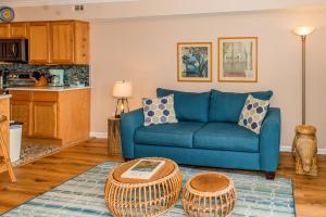 a living room with a blue couch and a table at What A View in Carolina Beach
