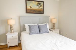 a bedroom with a white bed with two night stands at What A View in Carolina Beach