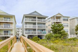 a boardwalk leading up to two apartment buildings at What A View in Carolina Beach