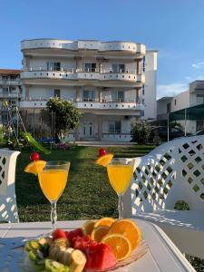 a plate of fruit and two glasses of orange juice at Apartmens Xhenis Lux in Ulcinj