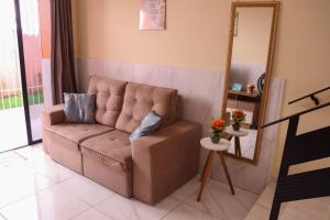 a brown couch in a living room with a mirror at Casa Lua Nova na Praia de Peroba, Maragogi in Maragogi