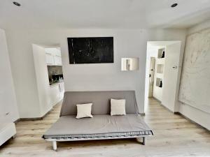 - un canapé gris dans une chambre aux murs blancs dans l'établissement [Abstract house] Design home in center of Turin, à Turin