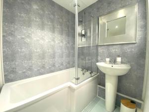 a bathroom with a sink and a bath tub and a toilet at LOVELY STYLISH APARTMENT NEAR PENNY LANE! FREE PARKING in Liverpool