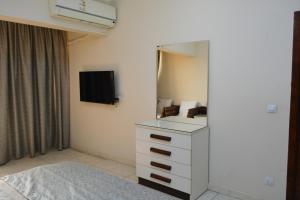 een slaapkamer met een witte dressoir en een tv bij شقه مفروشه 3 غرف امام سيتي ستارز in Caïro