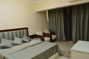 a hotel room with a bed and chairs in it at شقه مفروشه 3 غرف امام سيتي ستارز in Cairo