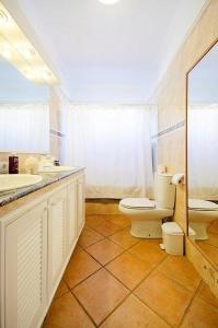 a bathroom with two sinks and a toilet and a mirror at Villa with Private Pool, Jacuzzi & 360° Sea Views in Callao Salvaje