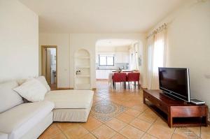 un soggiorno con divano bianco e TV a schermo piatto di Villa with Private Pool, Jacuzzi & 360° Sea Views a Callao Salvaje