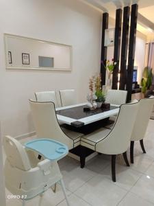 uma sala de jantar com mesa e cadeiras em Melissa Homestay Merlimau em Merlimau