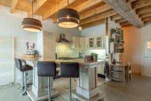 a kitchen with a large island with bar stools at Gastenverblijf Volkel in Volkel