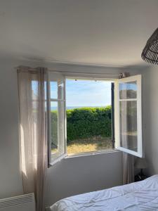 ein Schlafzimmer mit einem Fenster mit Blick auf ein Bett in der Unterkunft Maison de vacances en bordure de mer ! in Batz-sur-Mer + 20 Fotos