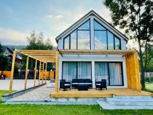 布什泰尼Chalet Alteo的一座小房子,配有甲板和黑椅子