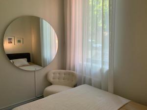 a mirror in a room with a bed and a chair at Vallikraavi Lux Apartment in Tartu