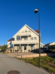 un gran edificio blanco con un coche aparcado frente a un semáforo en Vikerhavn, Hvaler, 