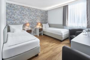 ein Hotelzimmer mit 2 Betten und einem Sofa in der Unterkunft Hotel Kraft in München