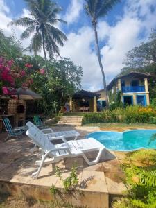 泰巴的住宿－Casa Jasmine Taíba，一座房子旁的游泳池,配有两把躺椅