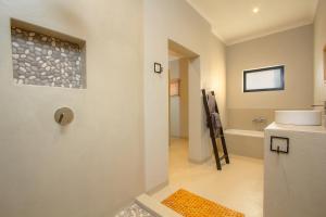a bathroom with a shower and a toilet in a room at Cheetah's Run in Marloth Park +16 photos