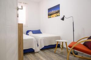 a room with two beds and a table and a chair at Apartment Tina in Ploče
