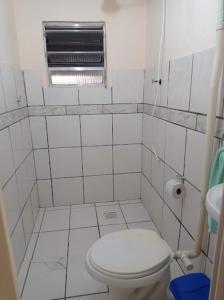 uma pequena casa de banho branca com um WC e uma janela em Pousada Videiras Santa Rita de Cássia em Cachoeira Paulista
