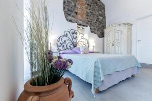 una camera da letto con un letto e fiori in un vaso di Casa Contrada Bella a Varenna