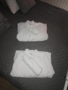 two stacks of white towels on a bed at R&M un moment de relaxation in Wardrecques