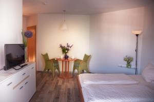 a bedroom with a bed and a table with chairs at Feriendorf Glasgarten in Rötz