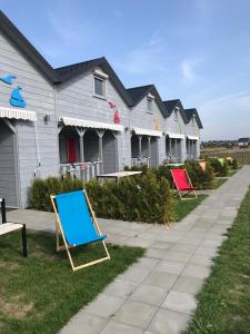 una fila de casas con sillas coloridas en el césped en Domki Perełka en Mielenko