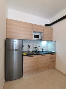 La cuisine est équipée d'un réfrigérateur en acier inoxydable et d'un four micro-ondes. dans l'établissement Art Apartment Clever, à Durrës