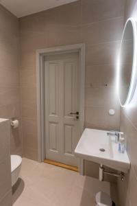 uma casa de banho com um lavatório, um WC e um espelho. em Vallikraavi Studio Apartment em Tartu