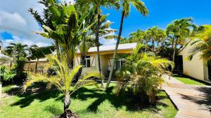 uma casa com palmeiras em frente em Île tropical lodges em Sainte-Anne