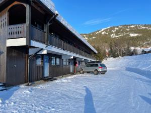 a car parked outside of a building in the snow at Spacious 2-bedroom holiday apartment - Hemsedal Veslehorn 14 in Hemsedal