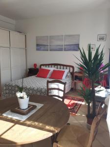 ein Wohnzimmer mit einem Bett und einem Tisch mit einem sidx sidx in der Unterkunft Studio Neptune in Arromanches-les-Bains