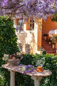 una mesa en un jardín con flores púrpuras. en B&B Glicine, en Ancona