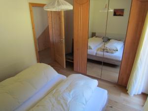 a room with two beds and a mirror at Oeberst-hof in Sarntal