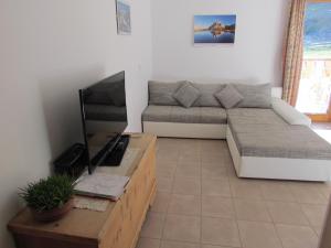 sala de estar con sofá y TV en Oeberst-hof, en Sarentino