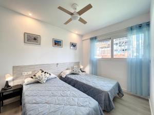 sypialnia z 2 łóżkami i wentylatorem sufitowym w obiekcie Apartamento cerca del mar w Alicante