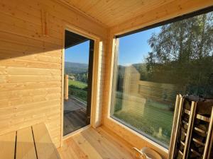 a view from the inside of a wooden cabin with a large window at Apartamenty Carpe Diem in Ustroń