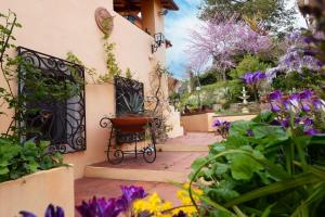 un giardino con cancello e fiori viola di B&B Glicine ad Ancona