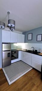 cocina con armarios blancos y horno de acero inoxidable en Warsaw Praga Apartment, en Varsovia
