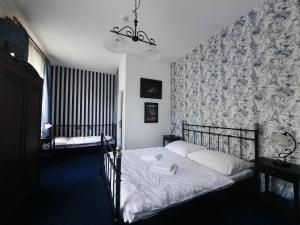 KolinecにあるZámek Jindřichoviceのベッドルーム1室(ベッド2台付)が備わります。壁紙を用いた内装です。