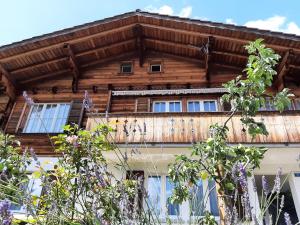 a wooden house with a wooden roof and windows at Cozy Chalet by Interlaken. Parking in Ringgenberg